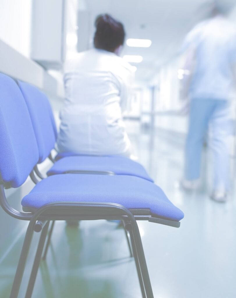 Medical workers in urgent care waiting area and hallway.